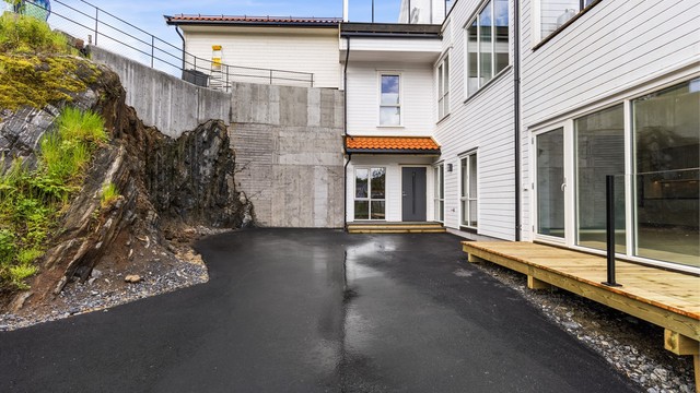 Asfaltert og lettstelt uteområde ved inngangspartiet.