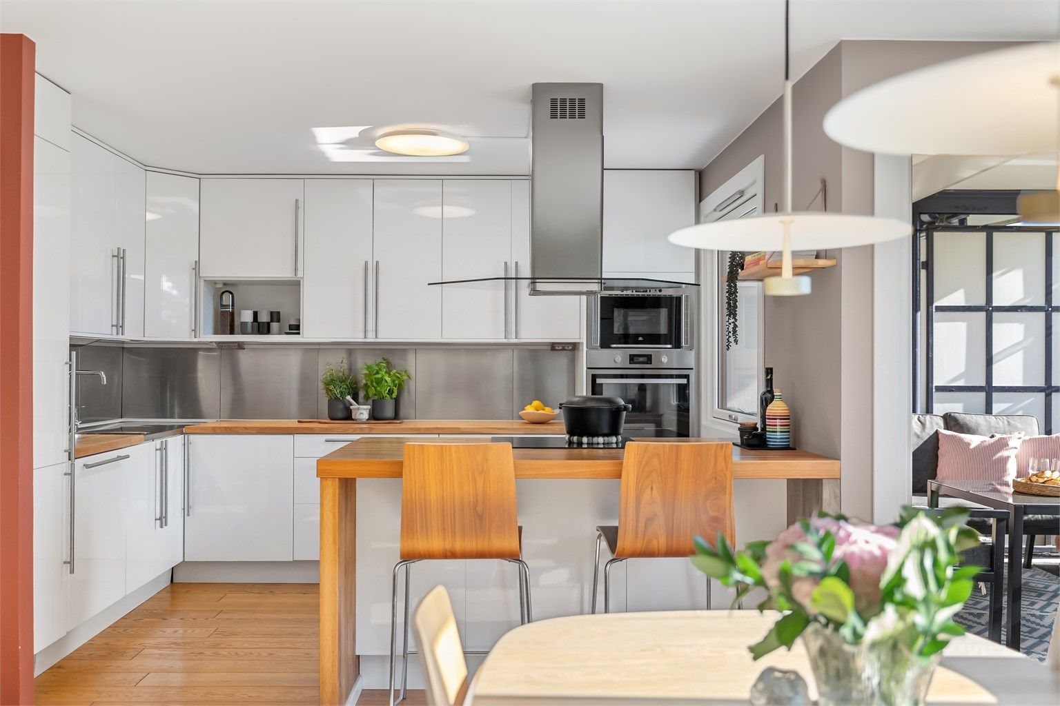 Kjøkkenet fra IKEA har glatte høyglansfronter og benkeplate i heltre med barløsning.