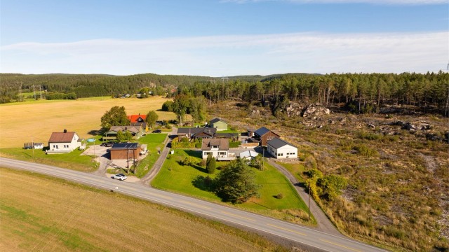 På den nær 2,9 mål store eiendommen er det foruten eneboligen fra 1953 oppført både dobbelgarasje og et nyere, stort garasjebygg.