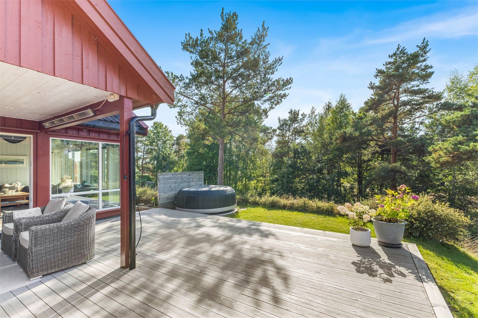 Stor terrasse med delvis overbygg som har belysning og varmelampe