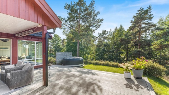 Stor terrasse med delvis overbygg som har belysning og varmelampe