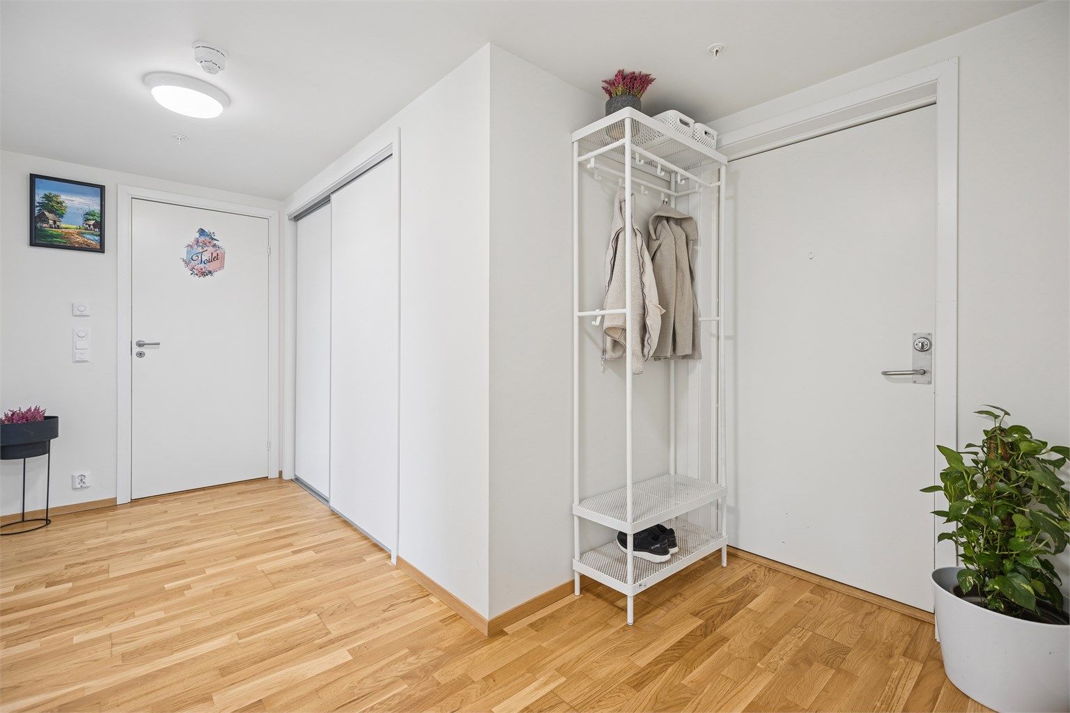 Du kommer inn i en romslig og klassisk entre, hvor et stort innebygd garderobeskap gir deg stil, orden og praktisk funksjonalitet.