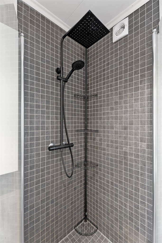 Praktisk dusjnisje med innfellbare dører og regndusj. 