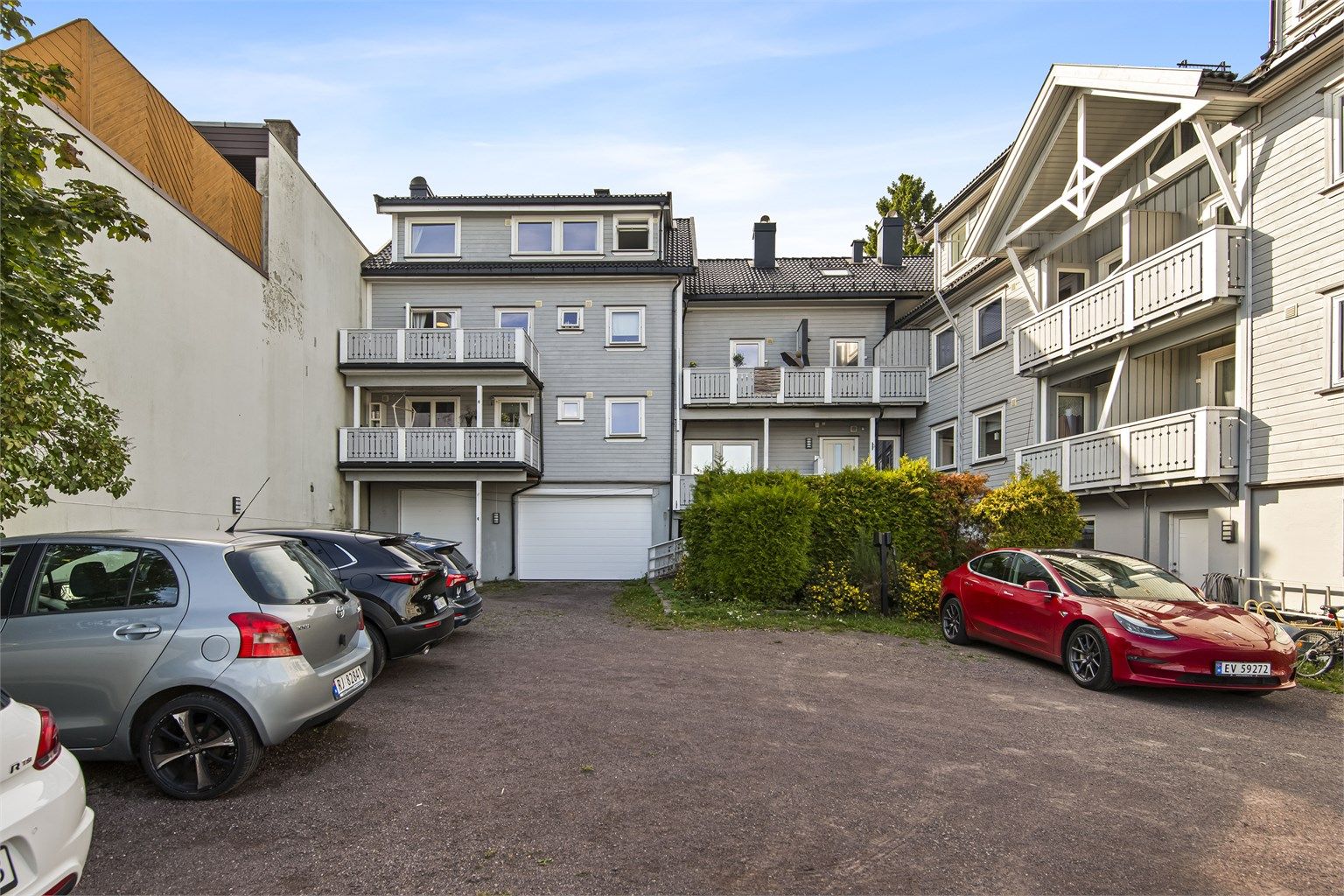 Felles parkeringsplass i bakgården. Borettslaget har felles ladestolpe for elbil.