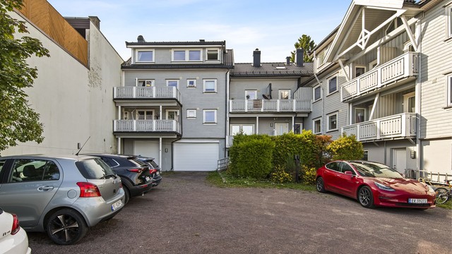 Felles parkeringsplass i bakgården. Borettslaget har felles ladestolpe for elbil.