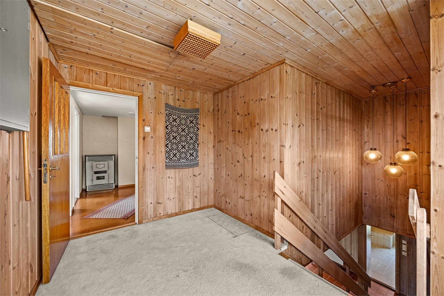 Trapperom og gang i andre etasje med panelkledde vegger.
