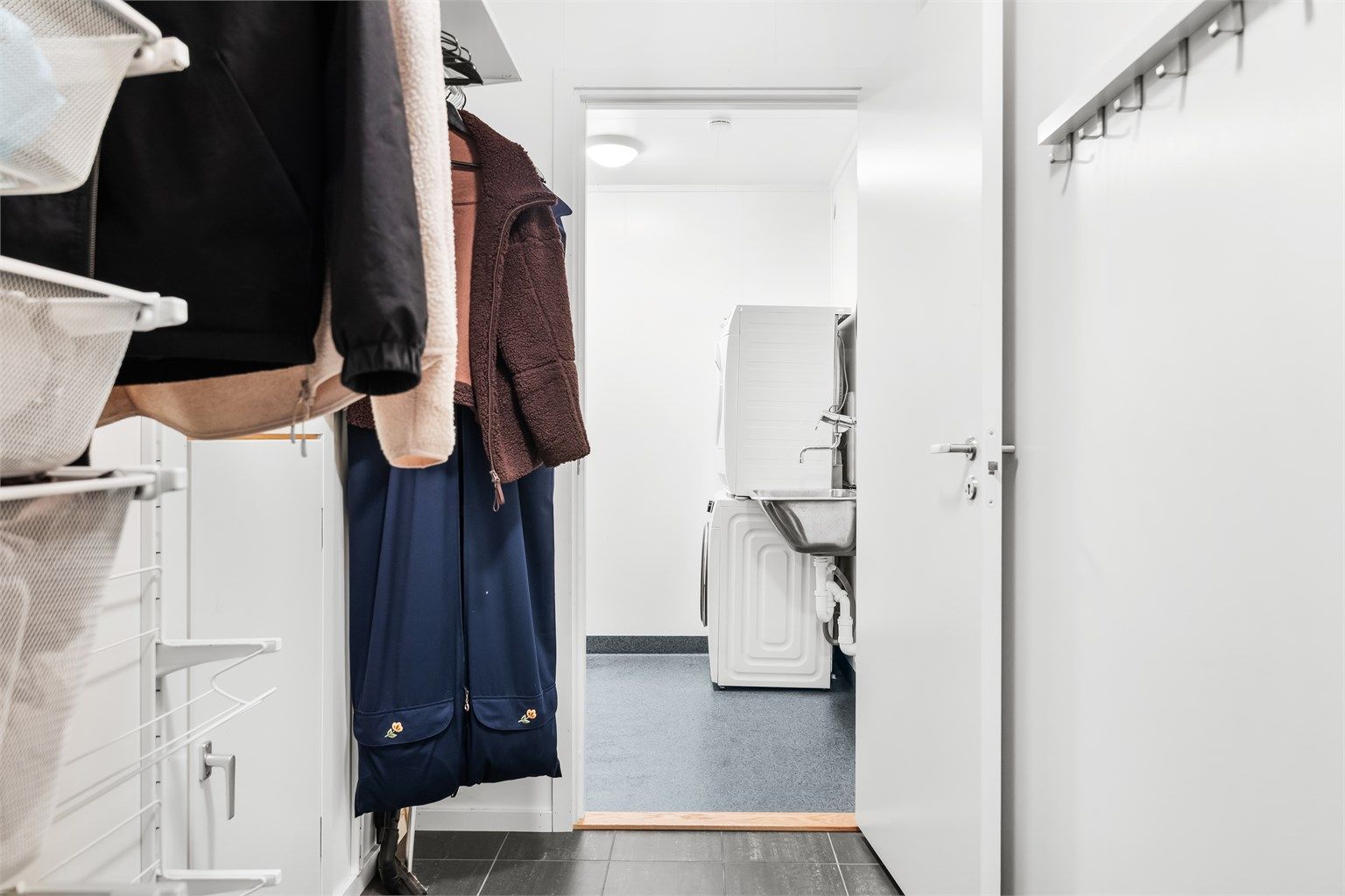 Fra garderoben i underetasjen er det inngang til et separat vaskerom og en praktisk bod innerst i garasjen.