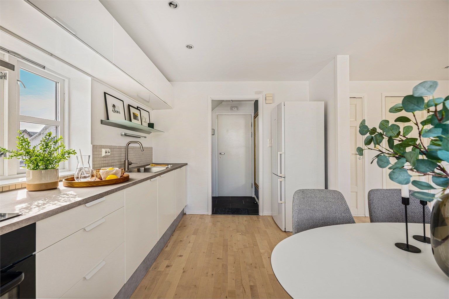 Kjøkkenet er i tidløst og fint design med hvite fronter og grå benkeplate. Kjøkkeninnredning er blitt oppgradert med ny benkeplate, lakkerte fronter og ny vask. 