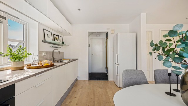 Kjøkkenet er i tidløst og fint design med hvite fronter og grå benkeplate. Kjøkkeninnredning er blitt oppgradert med ny benkeplate, lakkerte fronter og ny vask.