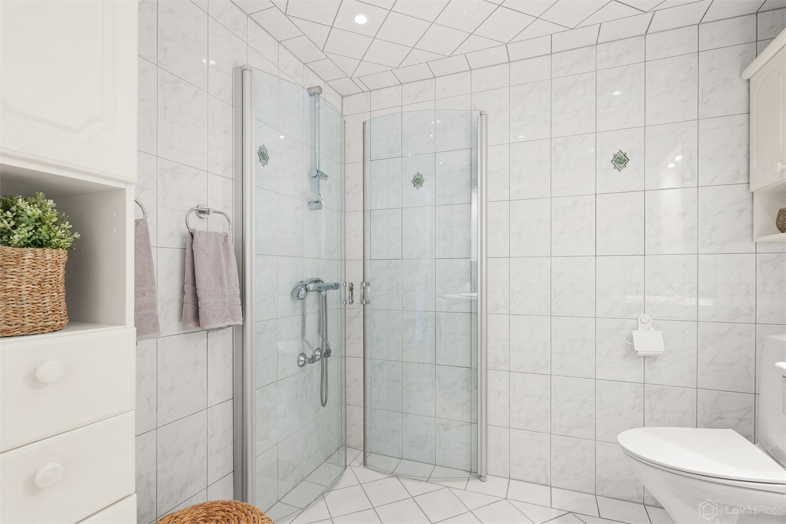Badet er utstyrt med dusjhjørne med innfellbare dører og mekanisk avtrekk.
