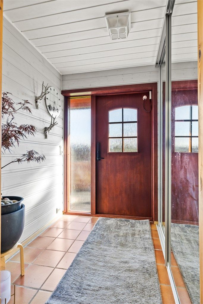 Velkommen inn! Entrè med varmekabler i gulv og garderobeskap med skyvedører. 