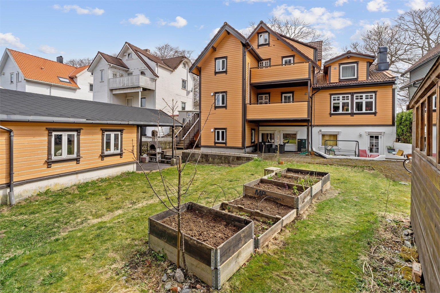 Tomten er opparbeidet med plenarealer og plantekasser.