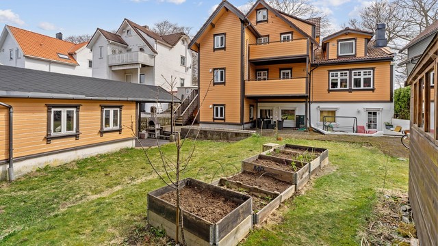 Tomten er opparbeidet med plenarealer og plantekasser.