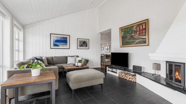 Koselig vinterhage med flislagt gulv og en fin peis for ekstra varme og hygge.