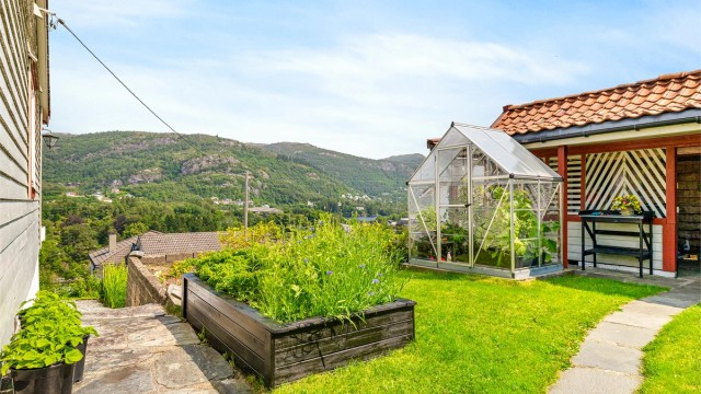 Gjennomtenkt hageanlegg som skaper en grønn og idyllisk ramme rundt boligen.