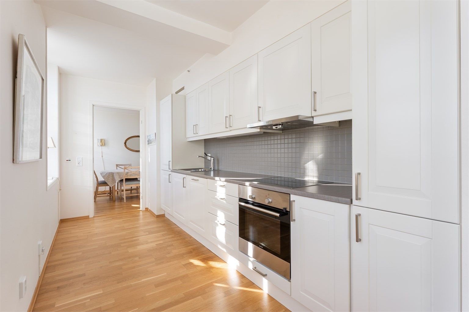 Kjøkkeninnredningen har profilerte fronter og integrerte hvitevarer.