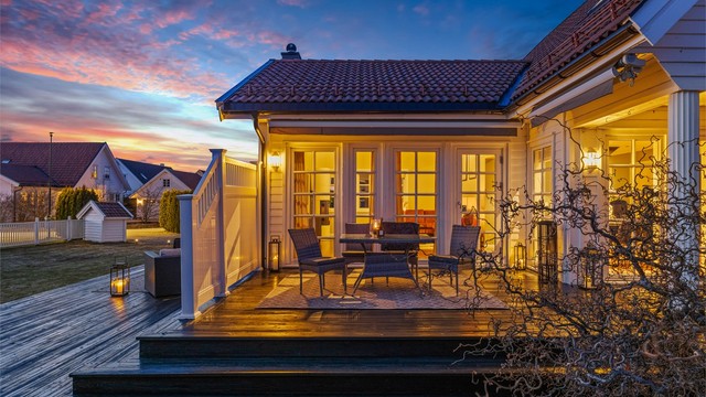 Utsyn over hagen og terrassen etter solnedgang.