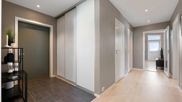 Romslig skyvedørsgarderobe i gangen gir gode oppbevaringsmuligheter.