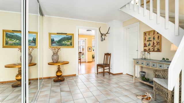 Den romslige entreen/hallen er et representativt første møte med boligens indre. Her er det god plass til å ta yttertøyet av og på for hele familien samtidig.