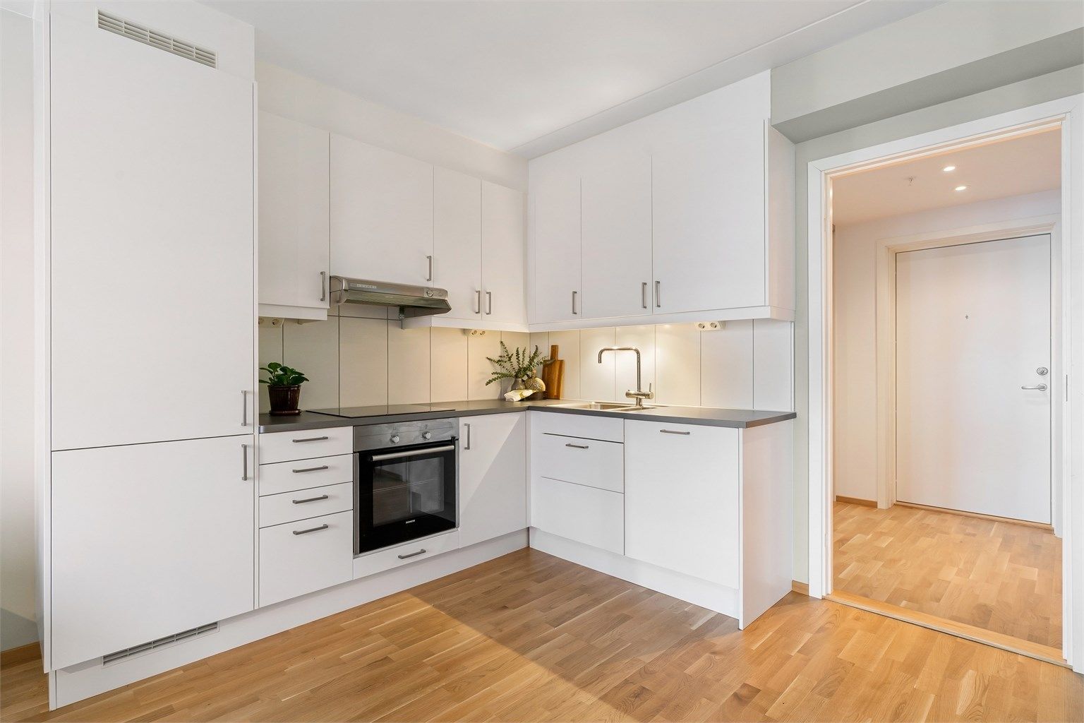 Kjøkkeninnredning fra 2017 med glatte fronter og benkeplate med laminert overflate.