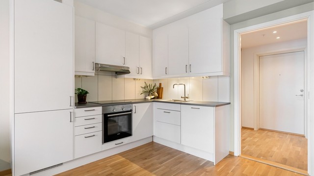 Kjøkkeninnredning fra 2017 med glatte fronter og benkeplate med laminert overflate.