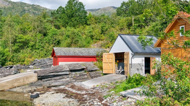 - Frittstående naust med støpt betongslipp ned mot sjøkanten -