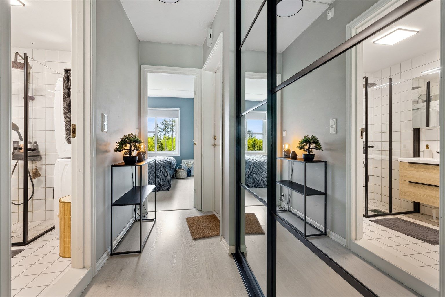 Entreen er lys og innredet med praktisk skyvedørsgarderobe med speilfronter