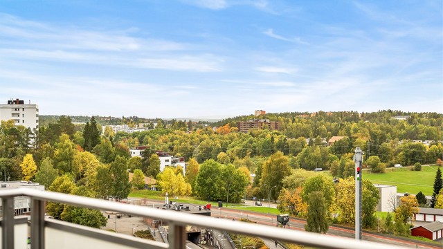 Utsikt fra balkongen mot Bogerud T-banestasjon og nærområdets grøntområder.