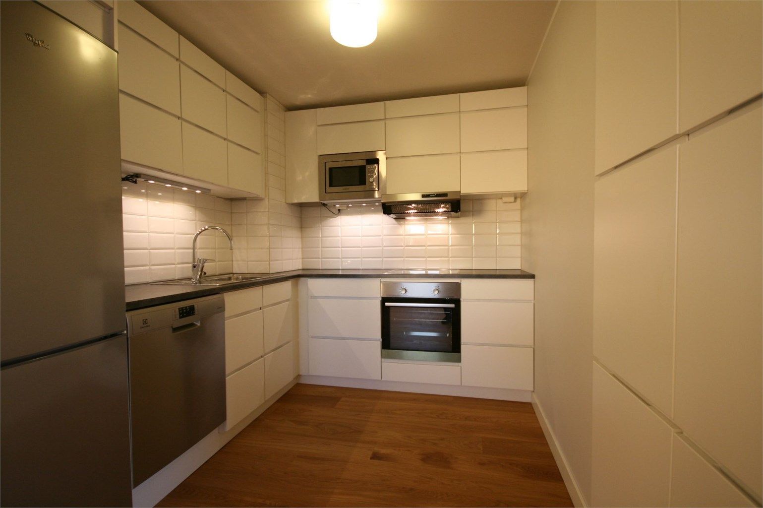 Nyere pent kjøkken med hvitevarer.