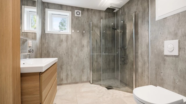 Badet har dusjhjørne med regnfallsdusj, downlights i tak og gulvvarme.