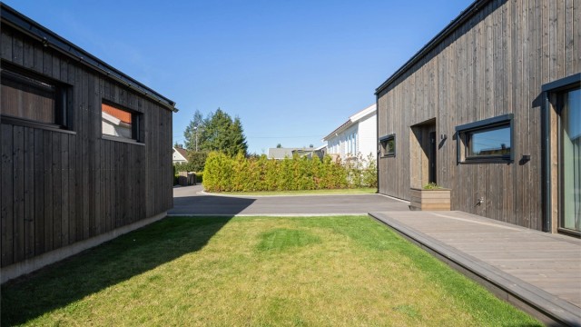 Tomten er lettstelt og innbydende, med en fin gressplen som gir plass til lek, avslapning og hyggelige uteaktiviteter.
