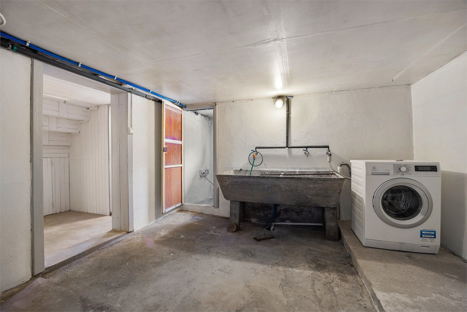  Separat vaskerom med gulvstående utslagsvask og vaskemaskin i kjeller 