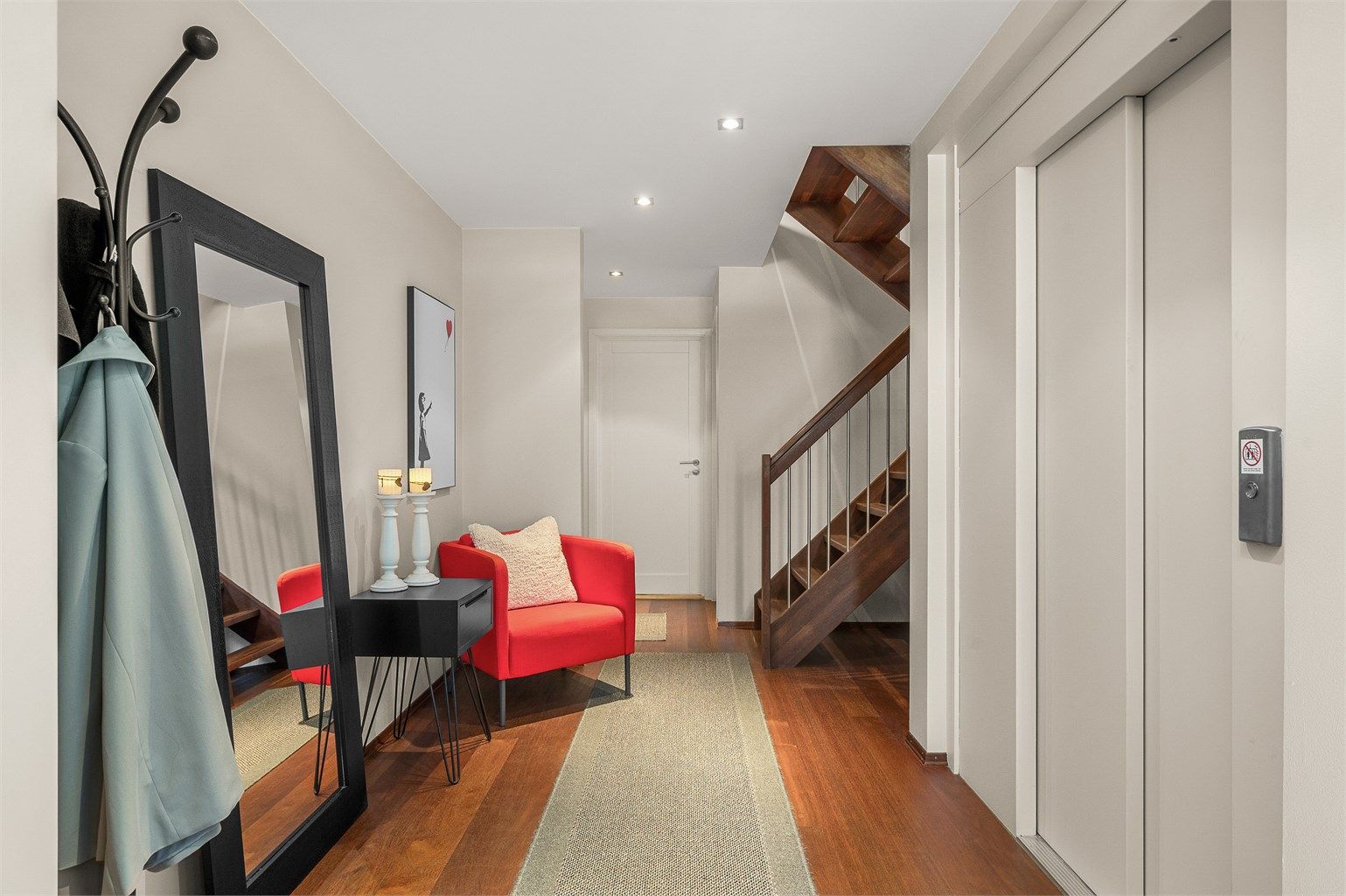 Gangen oppleves romslig og innbydende, med god flyt mellom etasjene og praktiske kvaliteter som både heis og trapp – løsning som gjør boligen ekstra komfortabel i hverdagen.