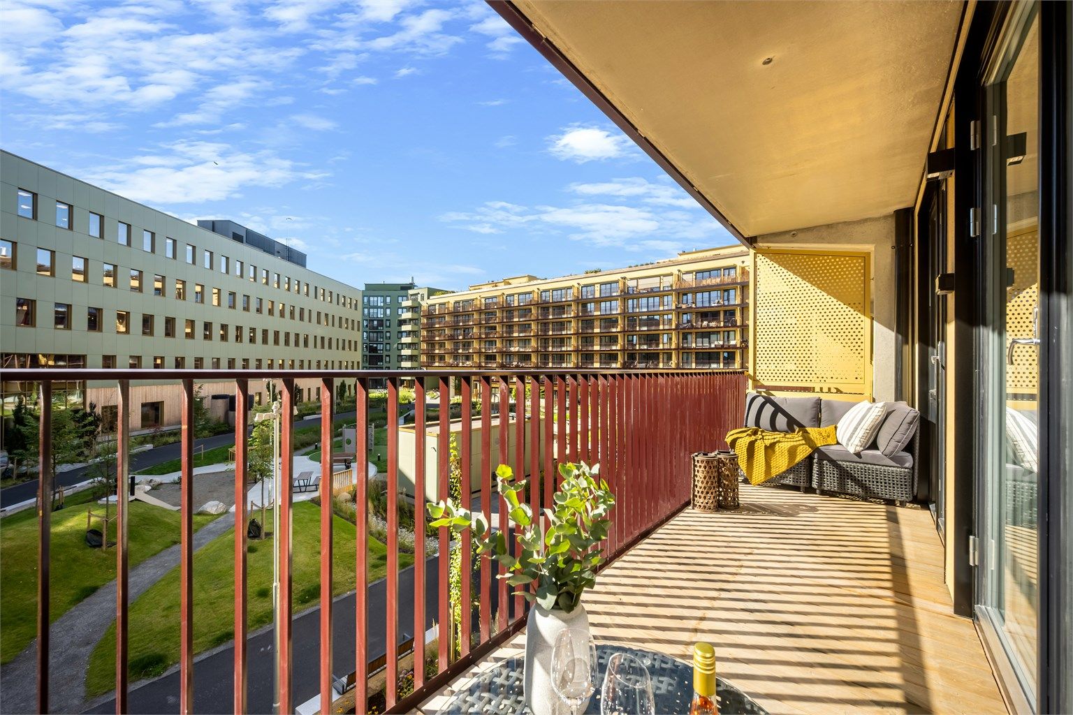 Moderne leilighet fra 2026 med heisadkomst og balkong med utsyn mot fellesområdet. Foto: Martine Eren Studio