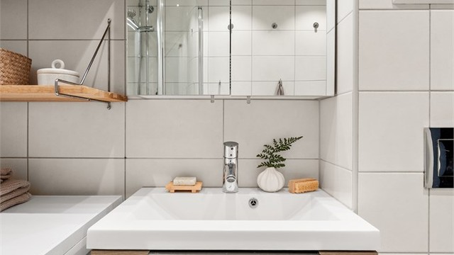 Badet har vegghengt servantinnredning med speilskap med overlys som gir god oppbevaring.
