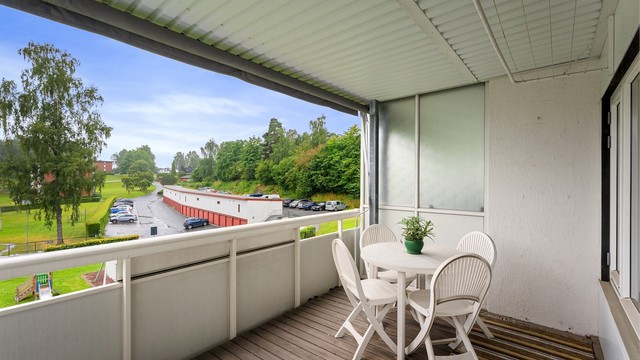 Balkongen har terrassebord på gulvet og plass til en sittegruppe.