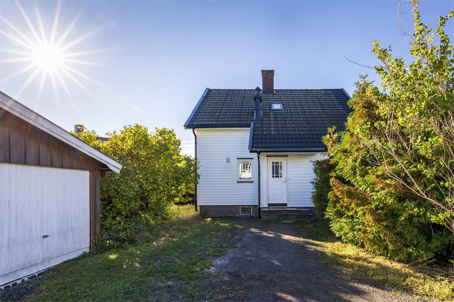 Eiendommen ligger skjermet til med adkomst og gårdsplass foran huset.