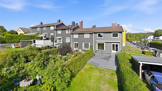 Stor og grønn hage med rikelig av plass for lek og utendørsaktiviteter.