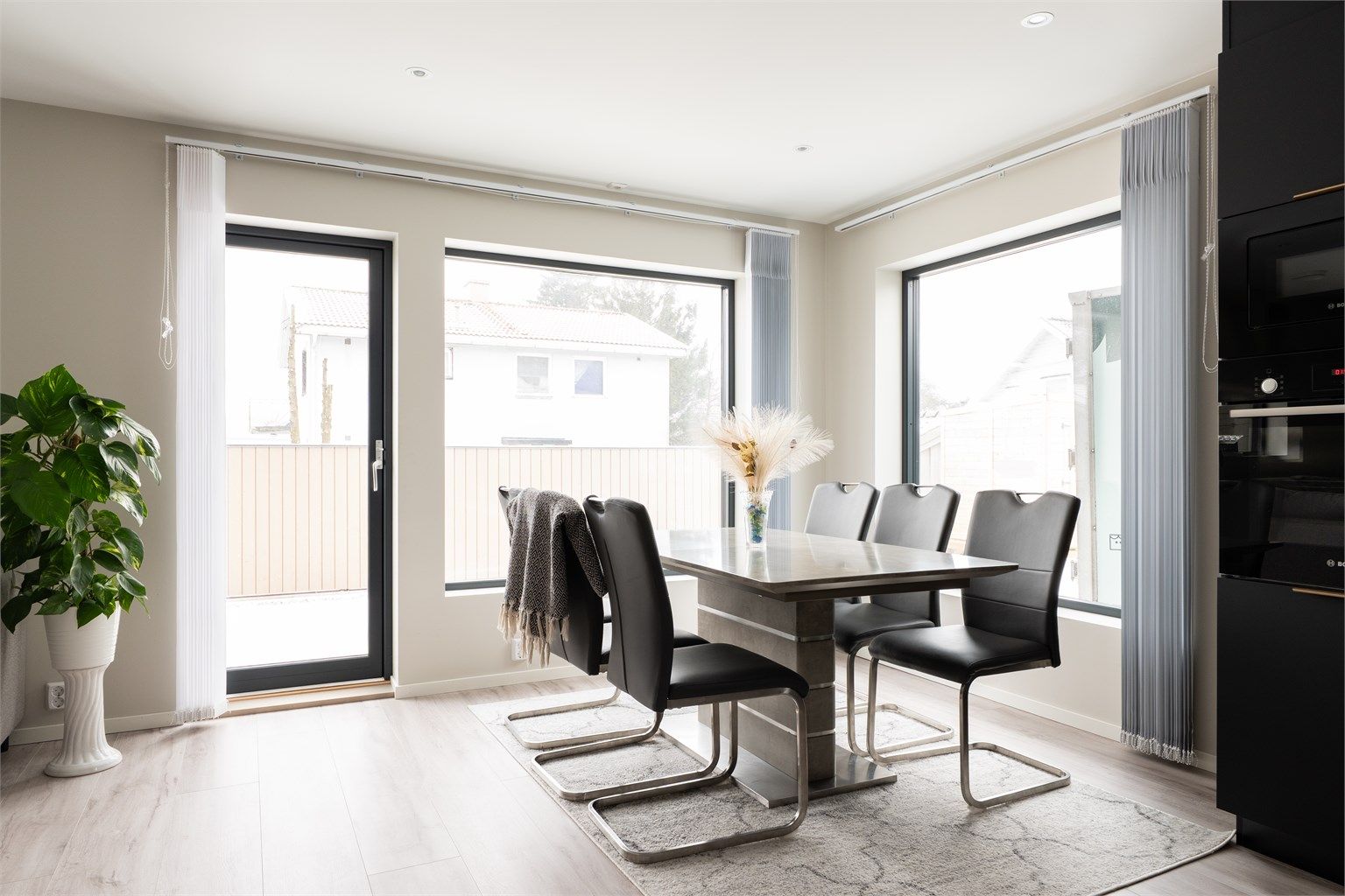 Store vinduer med tre-lags glass fyller stuen med mye naturlig lys.
Lamellgardiner skjermer effektivt mot så vel sol som innsyn.