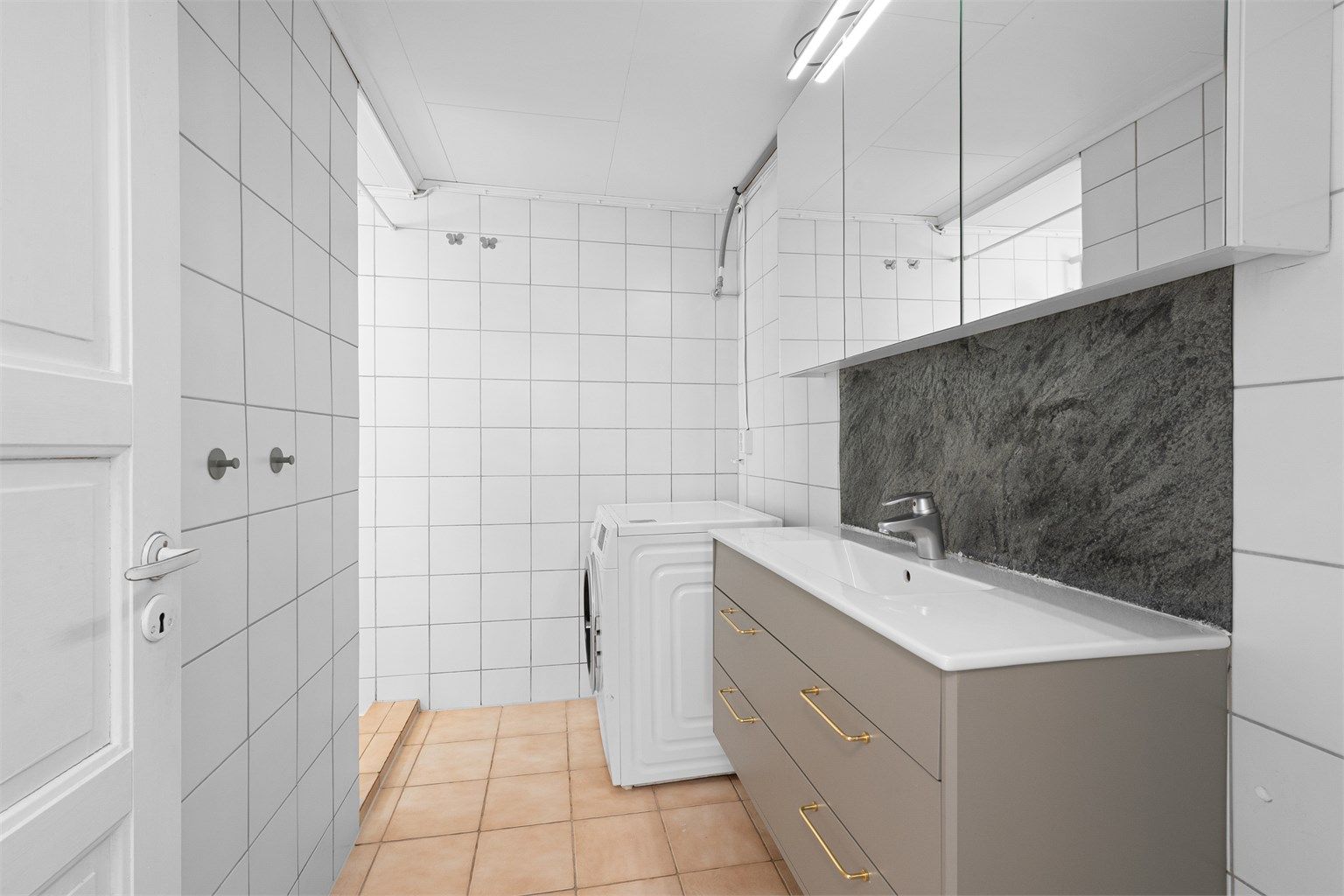 Badet i underetasjen er flislagt og har opplegg for vaskemaskin.