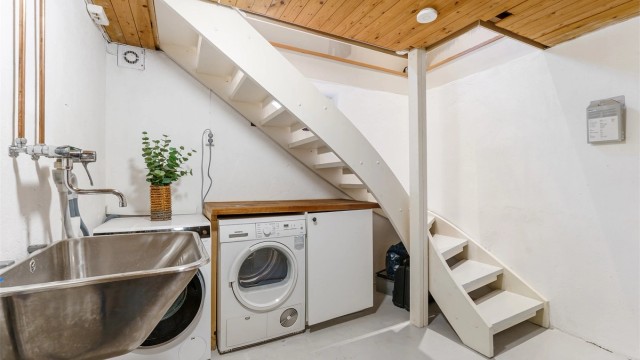 Praktisk vaskekjeller med opplegg for vaskemaskin og tørketrommel.