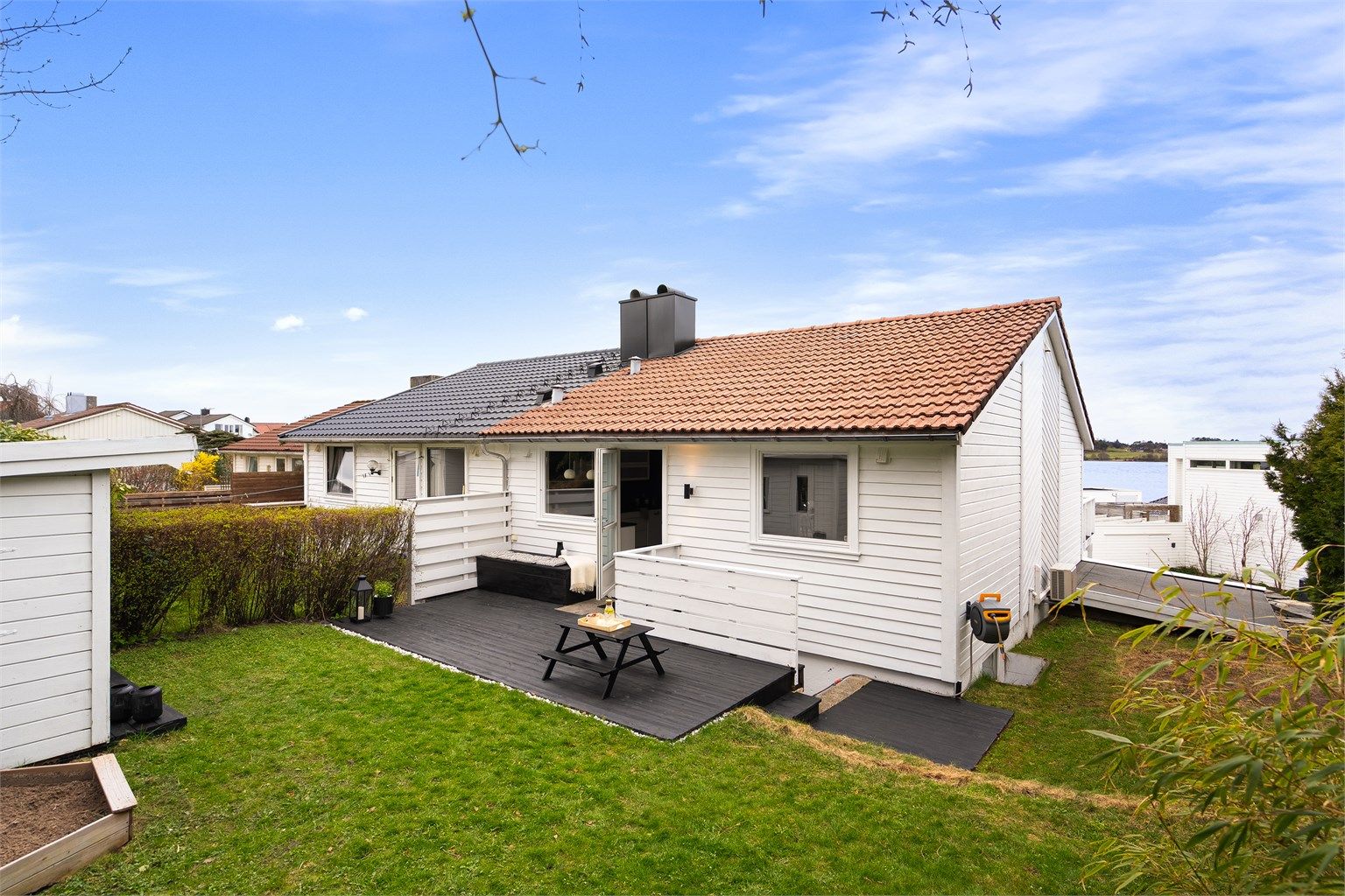 Fra kjøkken har man utgang til skjermet og inngjerdet terrasse og hage. Dette er et trivelig sted for både store og små og her kan man nyte morgensolen. 