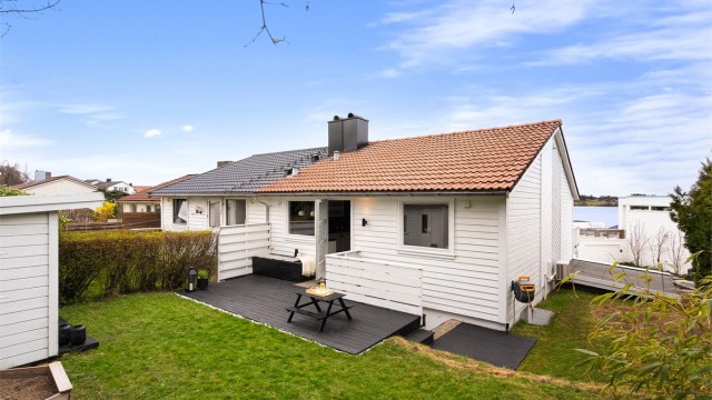 Fra kjøkken har man utgang til skjermet og inngjerdet terrasse og hage. Dette er et trivelig sted for både store og små og her kan man nyte morgensolen.