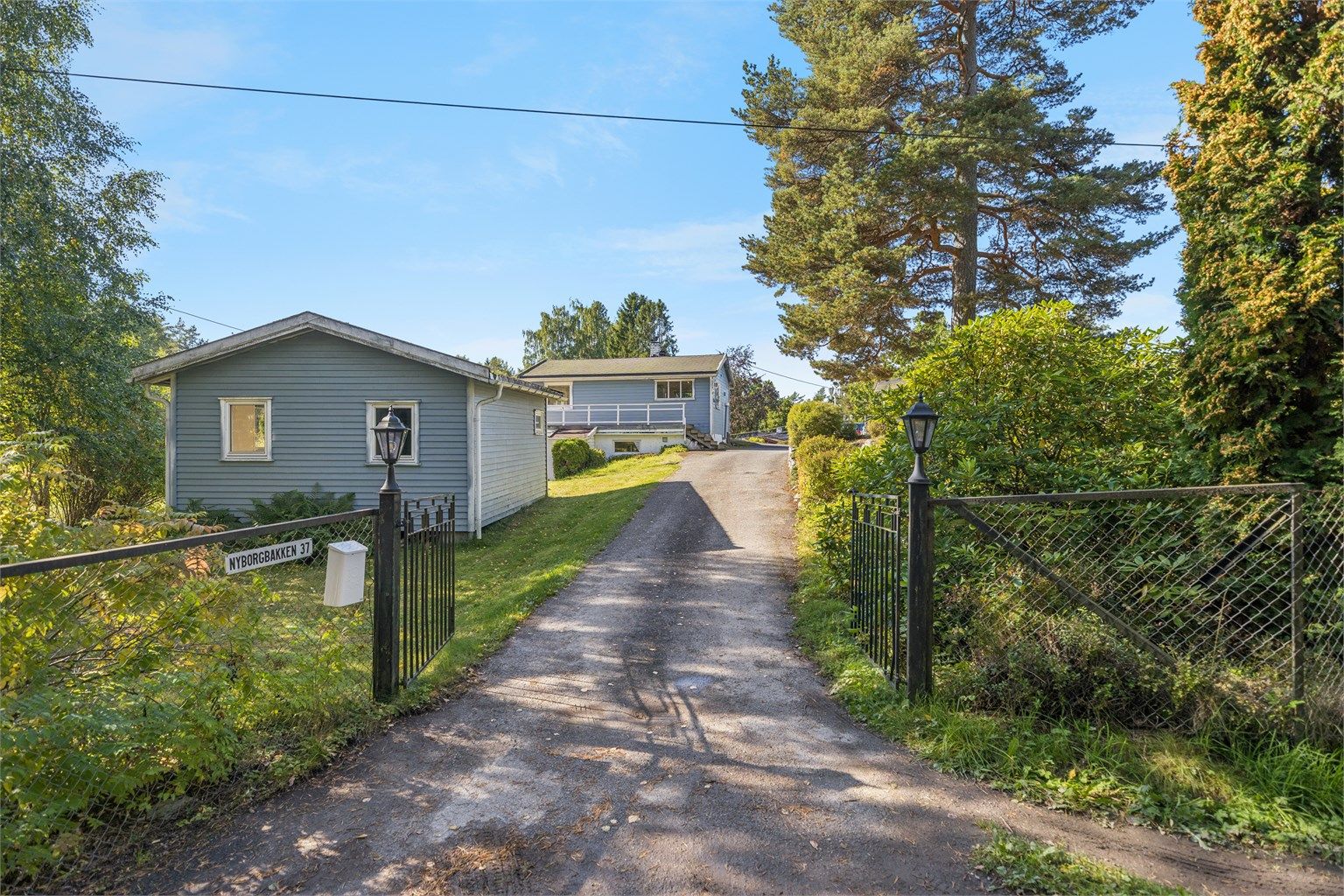 Velkommen! Den store eiendommen består av fritidsbolig med vinterhage, et anneks, og et uthus. Samt en stor solrik hage med ulik beplantning og opplegg for basseng. Foto: Per O. Skjellnan