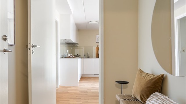 Velkommen inn! Den lyse entréen gir et elegant førsteinntrykk, hvor duse fargetoner og en gjennomført materialpalett skaper en rød tråd videre gjennom boligen.