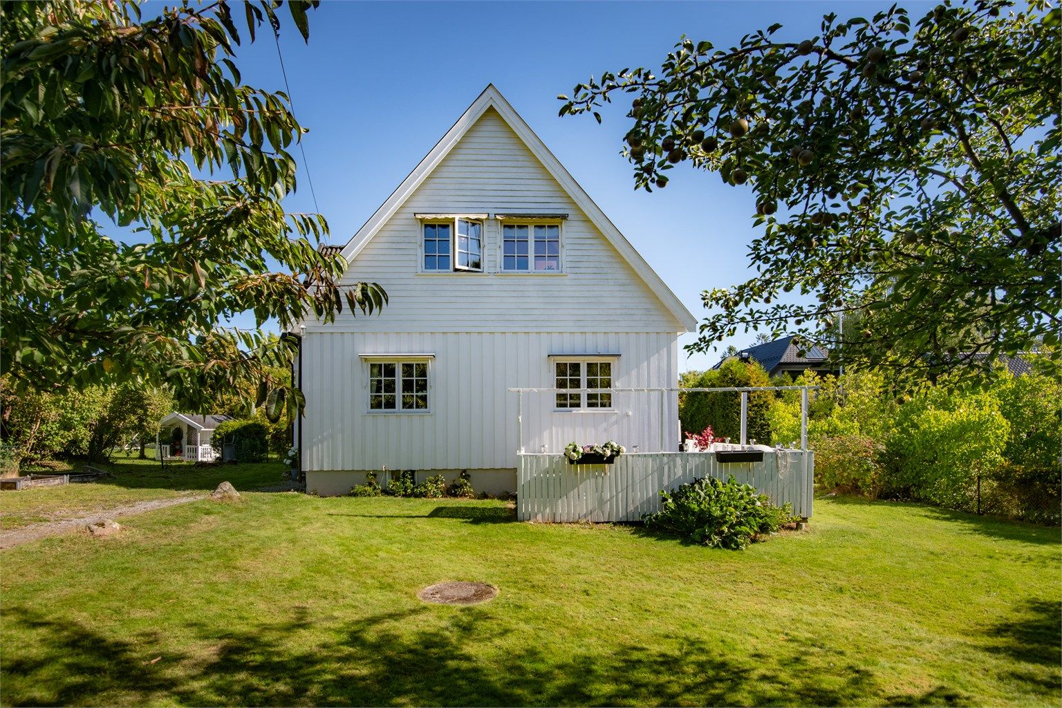 Flat og barnevennlig tomt opparbeidet med gressplen og frukttrær. Foto: Lars Gartå