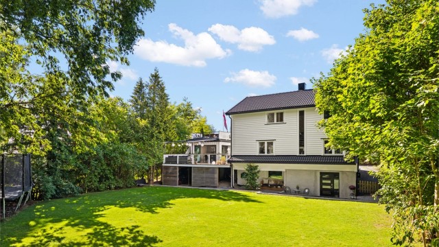 Stor, solrik og flat hage, ideell for lek og aktiviteter