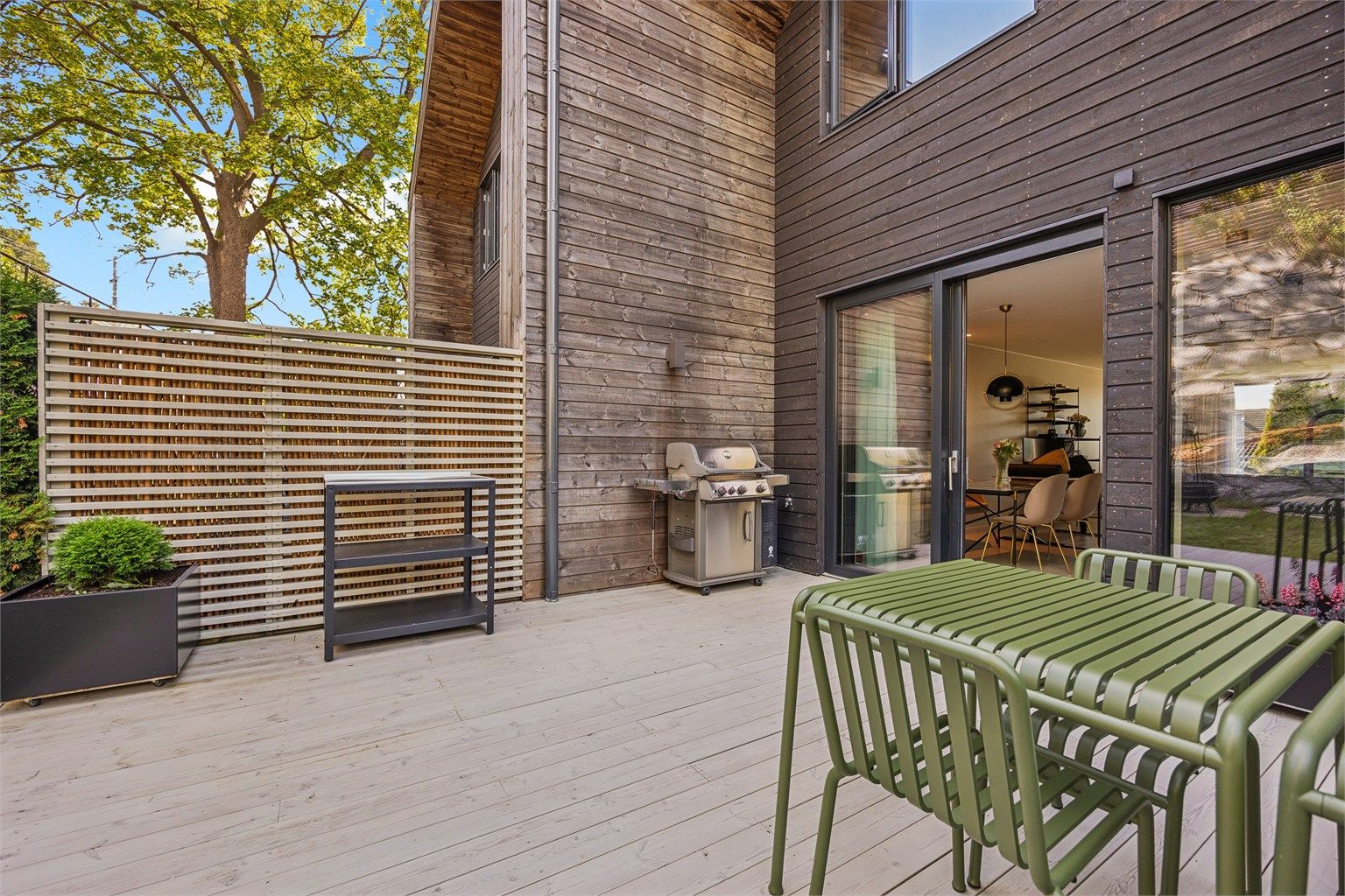 Terrasse utenfor kjøkkenet med god plass til sittegruppe og grill.