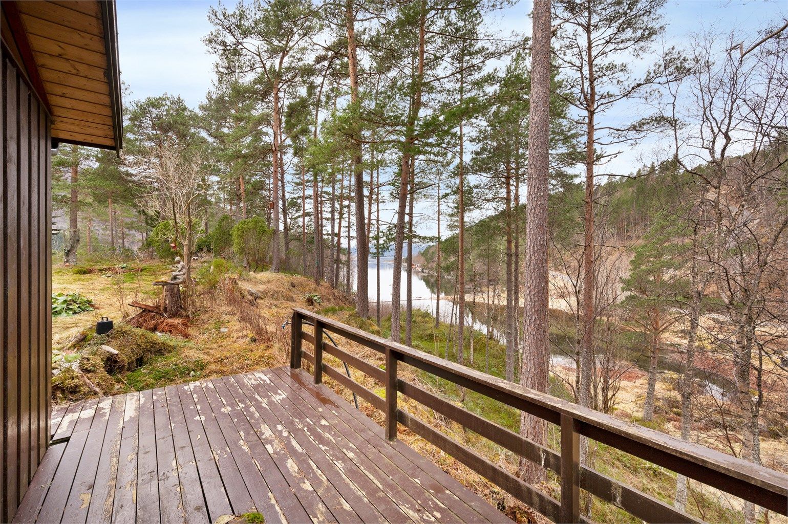 Tomta er delvis opparbeidet, og omkranset av naturlig vegetasjon er eiendommen skjermet for omgivelsene.