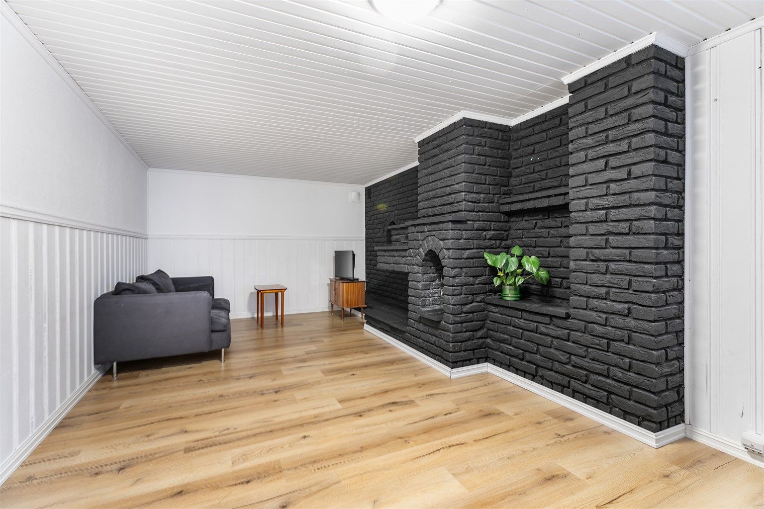 Rommet benyttet som stue utgjør over halve kjellerens areal. Her er det i nyere tid både uført malerarbeid og lagt nytt laminatgulv.